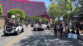 All Black Lives Matters protestors protest on top of a car in front of West Hollywood's Sherrifs to defund the police as the police watch