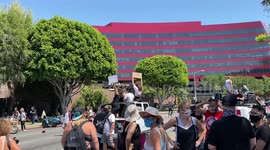All Black Lives Matters protestors protest on top of a car in front of West Hollywood's Sherrifs to defund the police as the police watch
