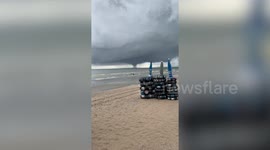 Spinning waterspout tornado looms over Thai coast as beachgoers play in sea