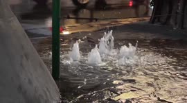 Water bubbles up through pavement after heavy rain in Bangkok