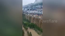 Rainfall causes flood and creates waterfall on bridge in southern China