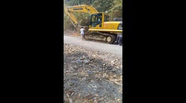 Workers in Vietnam use old tires to avoid damaging road when moving crawler excavator
