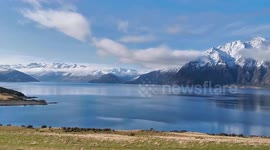 Lake Hawea, South Island, New Zealand. Picturesque view of snow peaked mountains and pristine waters.