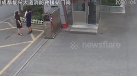Chinese fireman begins running into the station with daughter in his arm as siren goes off