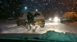 Man pushes car free from snow in UK