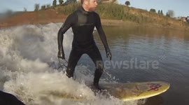 Surfers ride the Severn bore in freezing UK temperatures