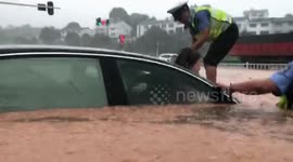 Chinese police officers break front windscreen to rescue motorist trapped in flooded car