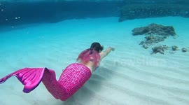 A mermaid glides through one of Minorca's turquoise-watered bays