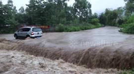 Firefighters rescue motorist after his vehicle gets trapped on flooded road in China