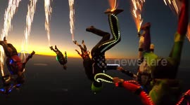 This stunning footage shows an insane troop of skydivers who free fall in the fading light leaving a trail of sparks in their wake.