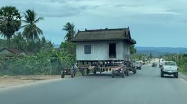 Cambodian family literally move house with help of tractors