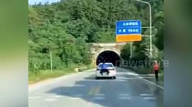 Chinese CD seller drives away trying to escape fine with official hanging onto to his car