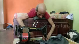 Paralysed man in India works sewing machine from bed to support his family