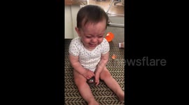 Adorable baby cannot stop laughing at his mum while she juggles