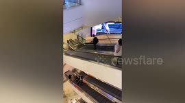 Guy rests his leg on escalator handrail