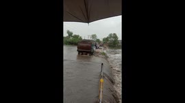 Three people swept from bridge in India during flash floods