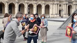 Tour guides hold Mona Lisa portraits as they protest during reopening of the Louvre Museum in Paris