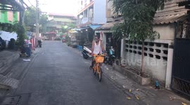 Cyclist rides with pet chicken on shoulder