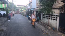 Cyclist rides with pet chicken on shoulder