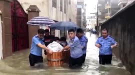Chinese police officers transport students in water bucket through deep floodwater to exam centres
