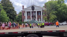 Construction workers dismantle the Jefferson Davis Confederate Memorial on Monument Avenue in Richmond, Virginia and lift statue with crane onto truck