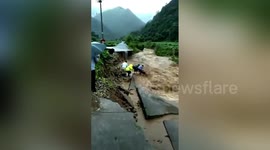 Chinese rescuers desperately hold elderly man caught up in torrential floods
