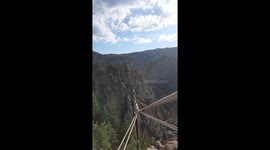 Pro Slackliner performs stunt while suspended over sheer drop