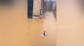 Chinese motorist dances on car roof after floodwater submerges city streets