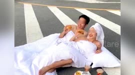 Chinese couple lay down on busy road to take candid wedding photos