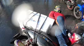 Delivery rider skids on wet road crashing into pickup truck in front
