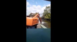 Excavator driver uses vehicle's bucket to row down river in Vietnam