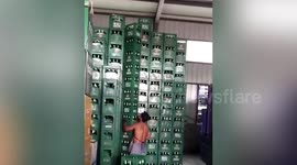 Chinese worker lifts stack of nine boxes of beer in one go