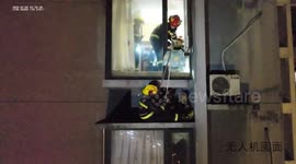 Chinese firefighters save mother and son trapped on ledge during high-rise blaze