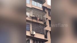Chinese firefighters rescue girl hanging from fifth-floor window