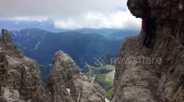 Mountaineers in the Dolomites scale cliff edge for breathtaking views