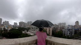 A girl enjoying the weather during a windy day in Mumbai