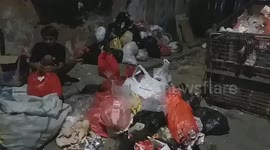 Garbage collectors pack the plastic waste that has accumulated on the roadside