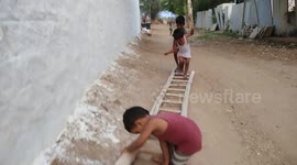 Village kids playing on ladder