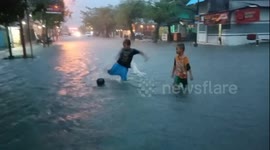 Kids play rainy street soccer during knee-deep flooding in Indonesia