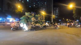 Overloaded motorcycle carries countless garbage bags on streets of Vietnam