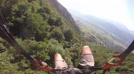 Speed flyer glides over stunning waterfall scene on French mountain