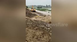 Chinese river embankment bursts and sweeps away excavators