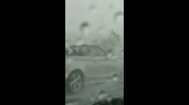 Man gets caught out driving his convertible BMW in rain storm