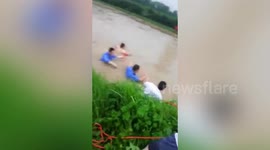 Chinese villagers venture in floodwater to rescue driver of submerged car
