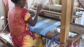 Woman weaving cloth using weaving machine at a local weaving mill run by the government Sri Lanka.