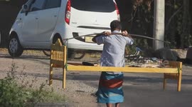 Street vendor selling a bed frame using a carrying pole to carry the bed on his shoulders in Boralasgamuwa, Sri Lanka.