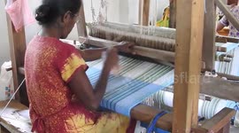 Newsflare Edit - Woman weaving cloth using weaving machine at a local weaving mill run by the government Sri Lanka.
