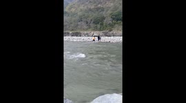 Rescue of couple of people stuck in strong current of the Ganges river in India