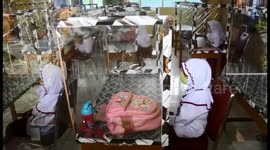 Schools in Indonesia reopen with children separated by plastic panels and wearing masks