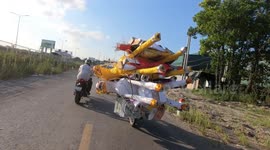 A motorbike transports paper replicas of various items to be sold for